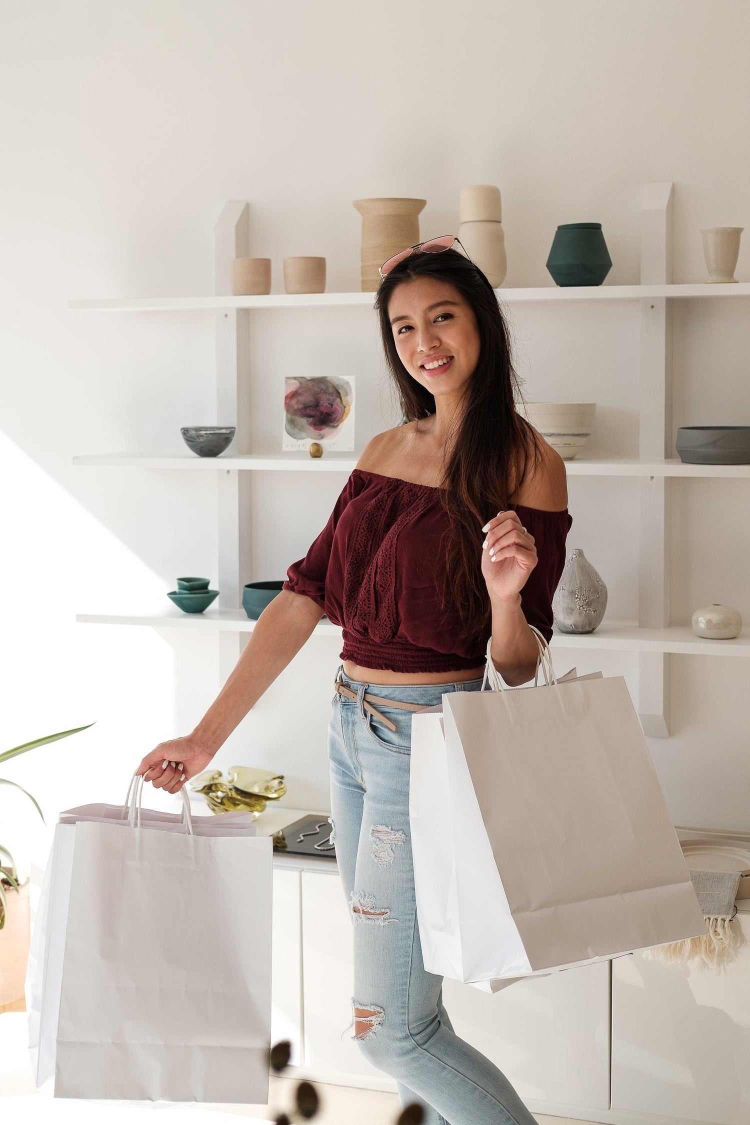 happy-customer-smiles-and-holds-white-shopping-bags - EcuCarrito